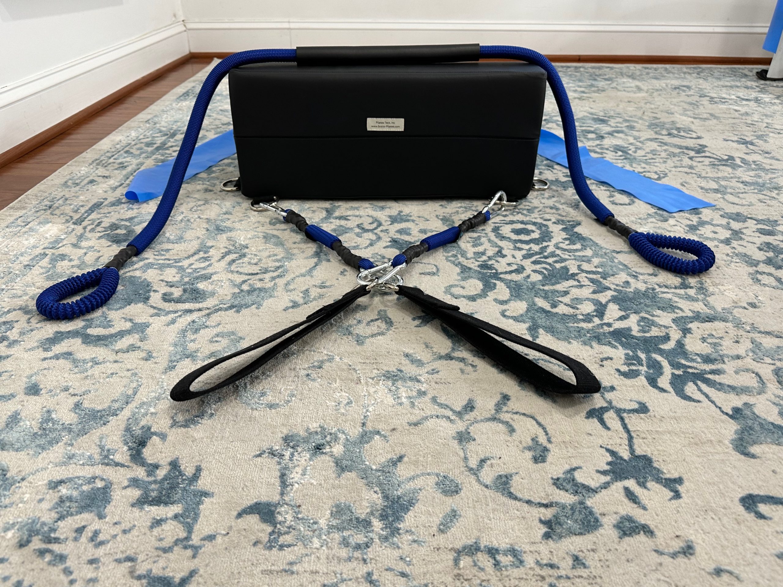 K-Fit wedge with blue bungee-style resistance cords looped over the top and flat resistance bands attached at the sides