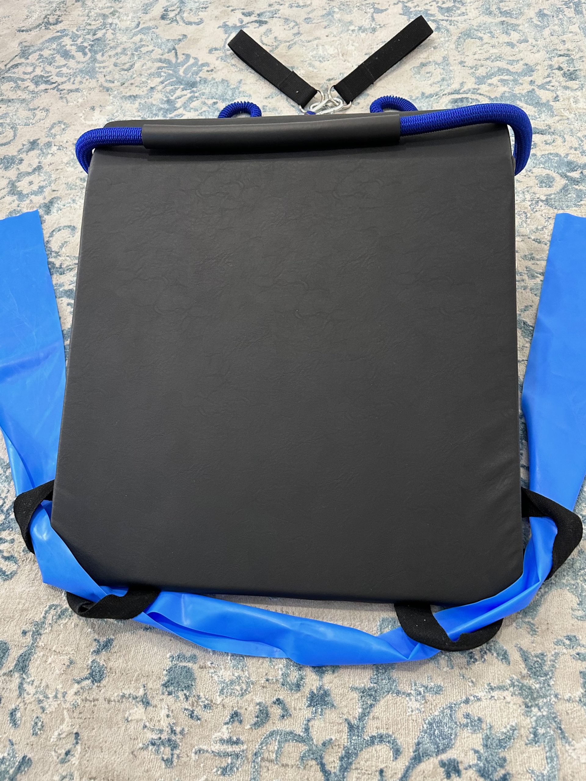 K-Fit wedge with blue bungee-style resistance cords looped over the top and flat resistance bands attached at the sides