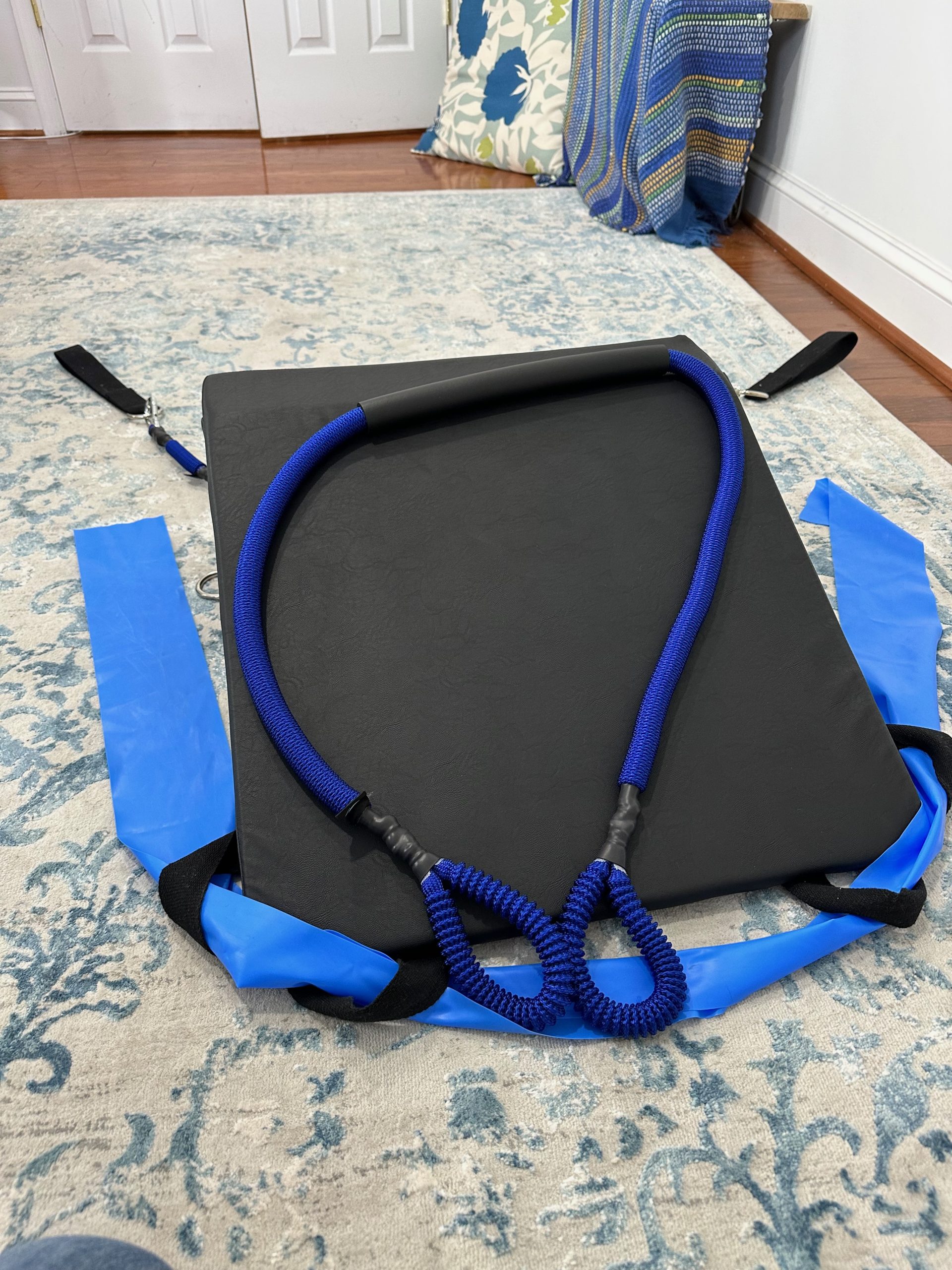 K-Fit wedge with blue bungee-style resistance cords looped over the top and flat resistance bands attached at the sides