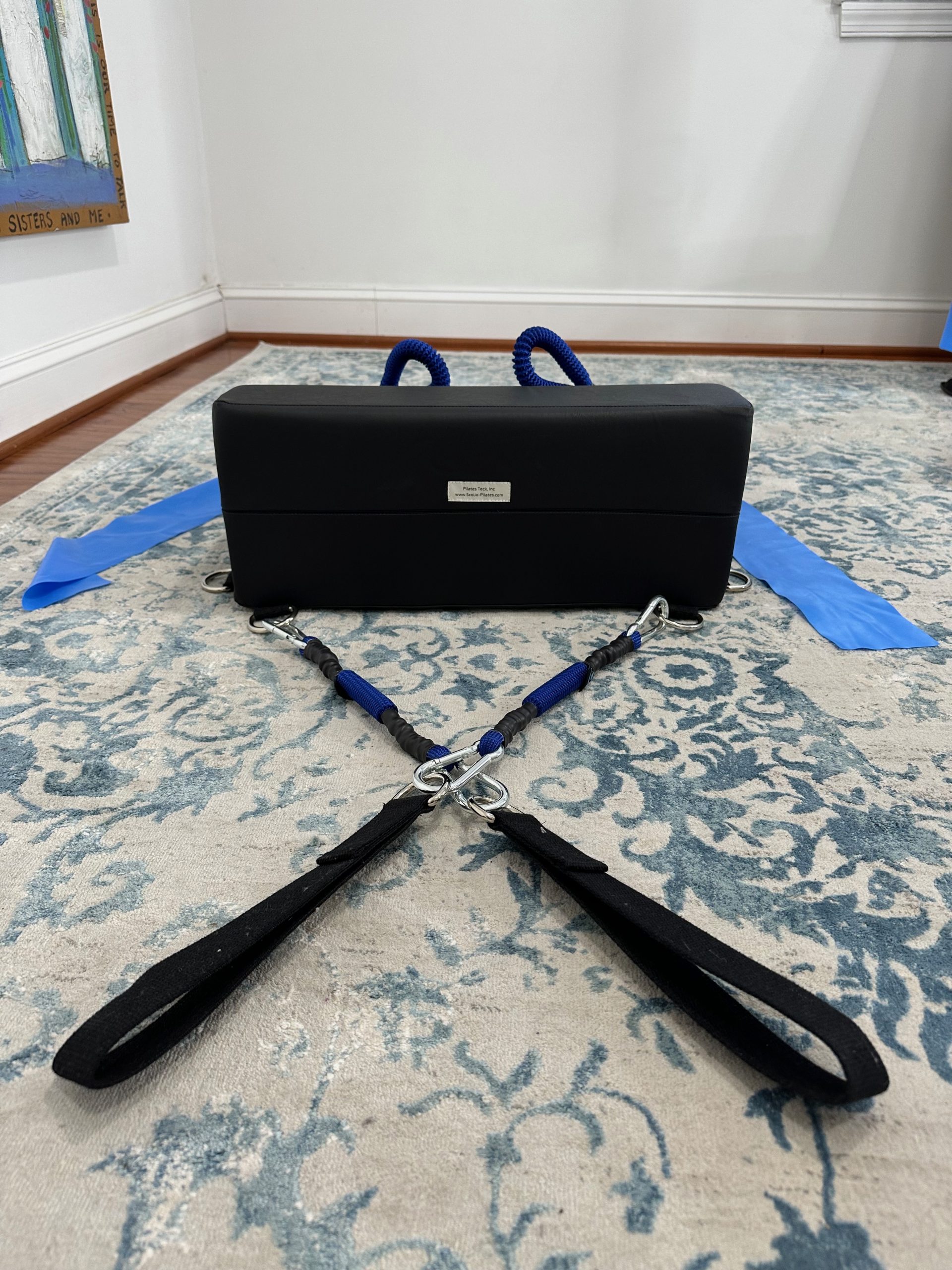 K-Fit wedge with blue bungee-style resistance cords looped over the top and flat resistance bands attached at the sides