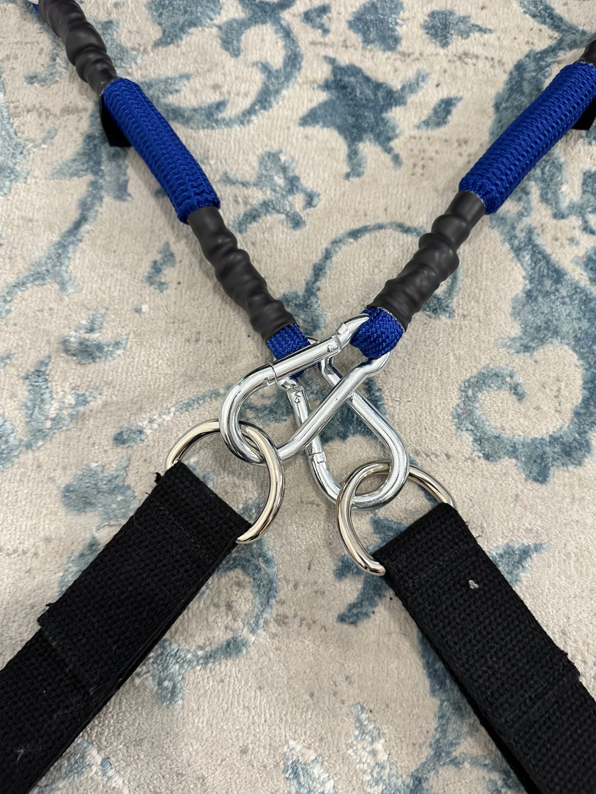 Close-up of the K-Fit wedge's carabiner clips connecting the resistance cords to fabric handles