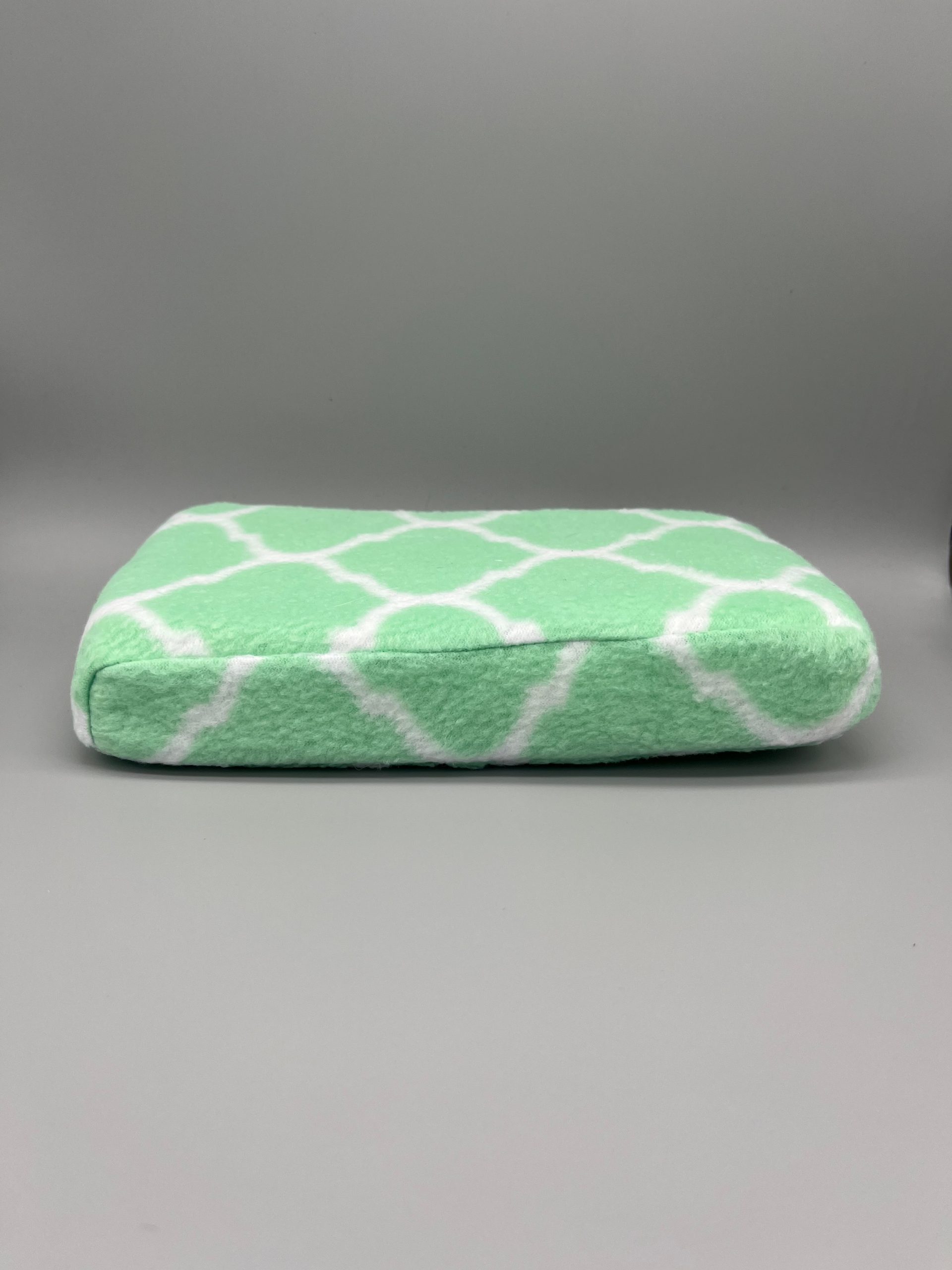Green and white patterned fleece-covered Scoli-Flat wedge shown from the side