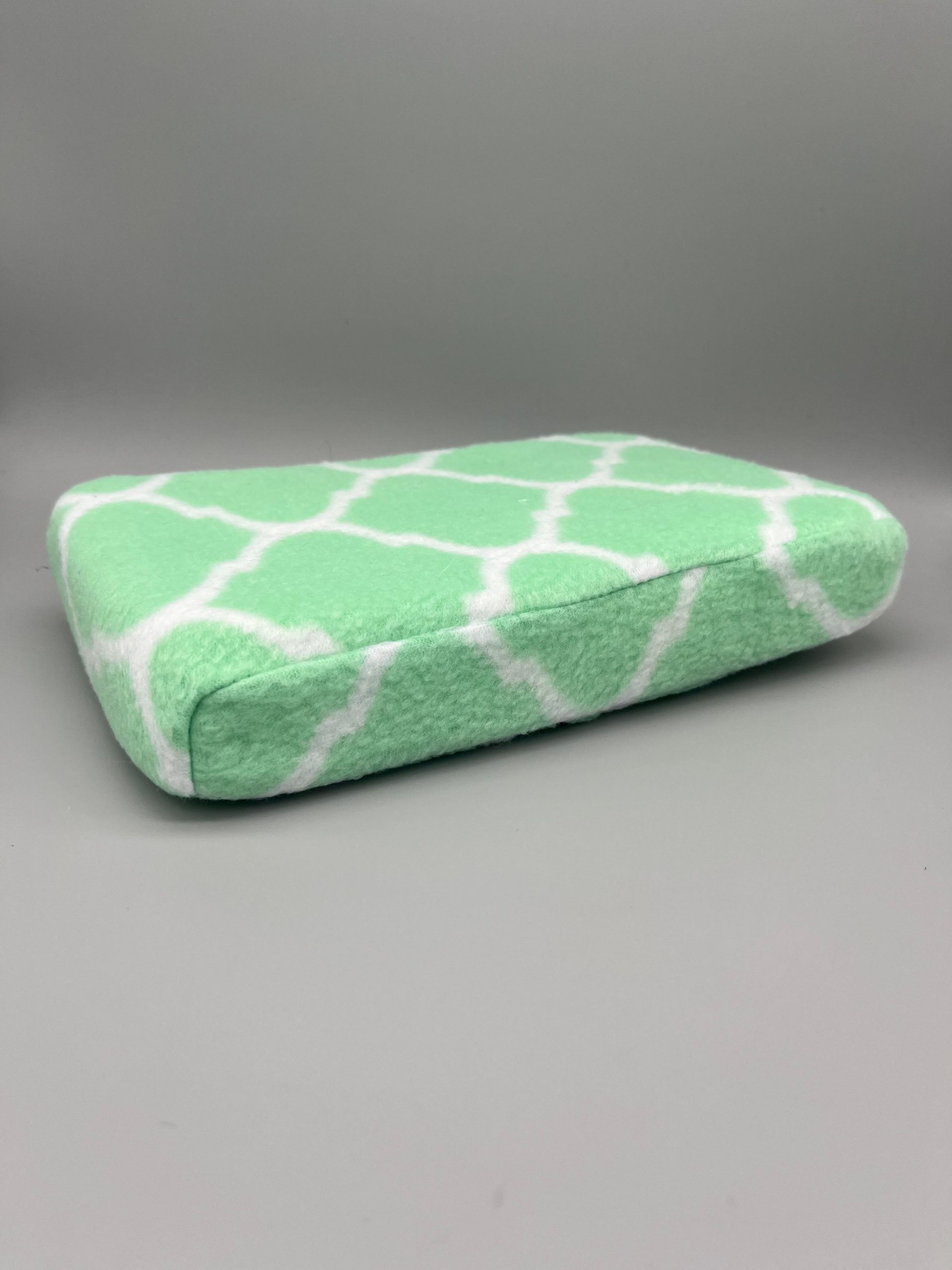 Green and white patterned fleece-covered Scoli-Flat wedge shown from the side