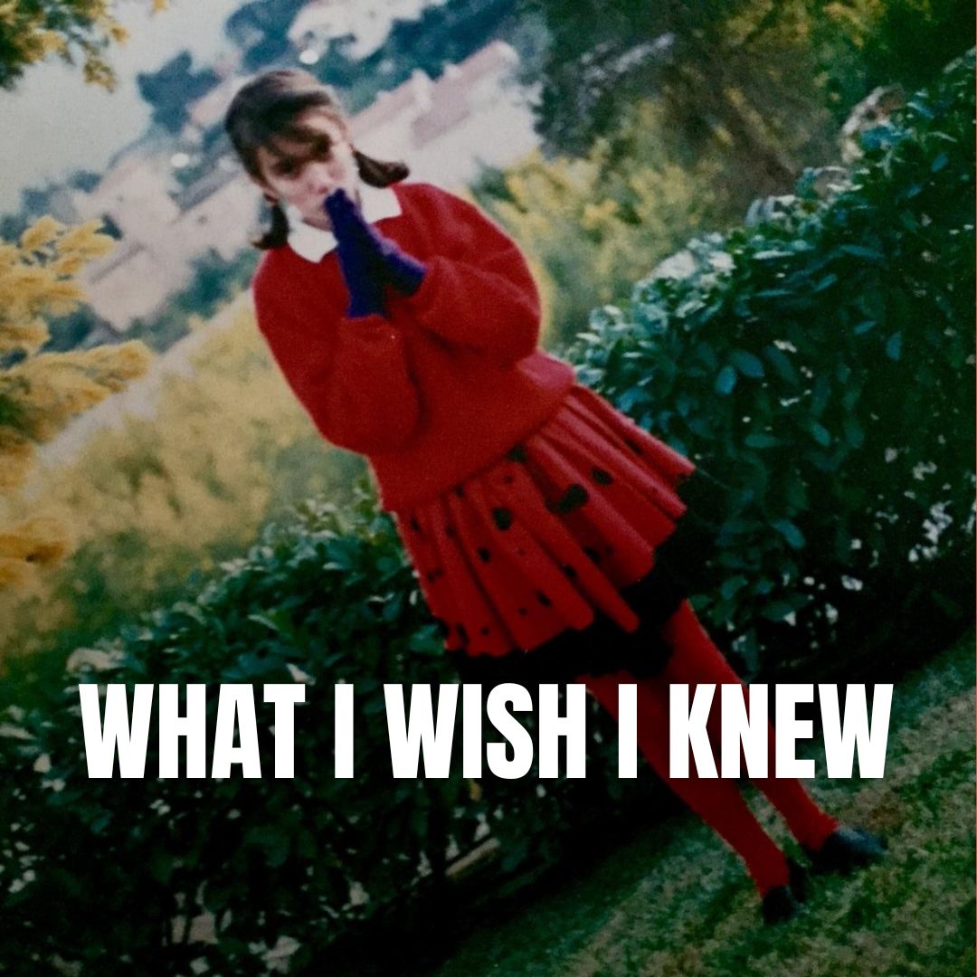 A young Nisreen Witt around age 10, dressed in a red sweater and skirt, standing in a garden with yellow flowering bushes, taken around the time of her scoliosis diagnosis.