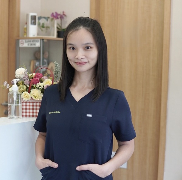 Dr. Anna Steven, Authorized Scolio-Pilates practitioner in Tangerang, Indonesia, standing in scrubs at her clinic