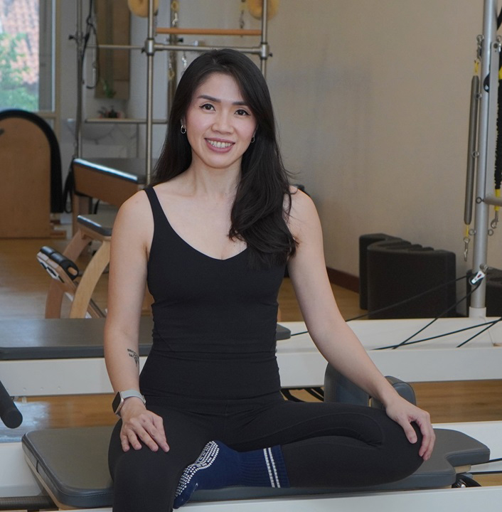 Chinta Barasilan, Authorized Scolio-Pilates practitioner in Sanur, Bali, Indonesia, seated on a reformer