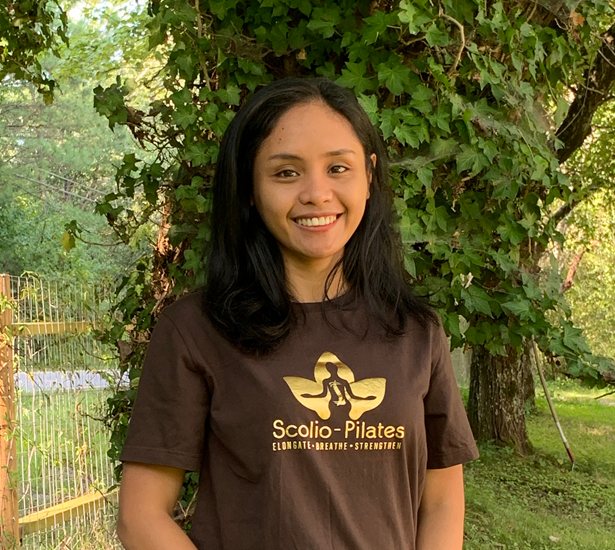 Gabriela Dawsey, Authorized Scolio-Pilates practitioner in Alabama, smiling outdoors in a Scolio-Pilates shirt