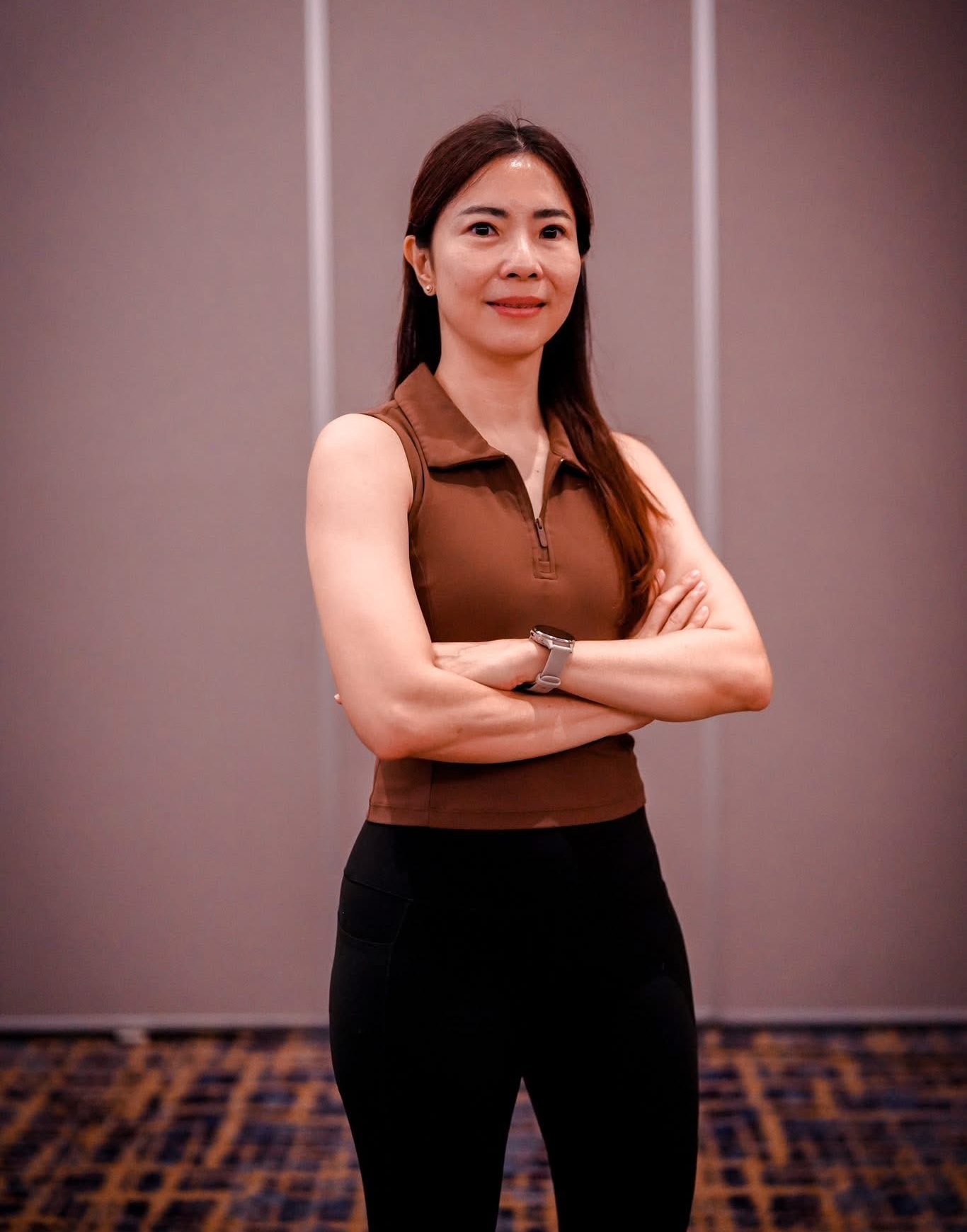 Linda Wati, Authorized Scolio-Pilates practitioner in Surabaya, Indonesia, standing arms crossed in a professional portrait