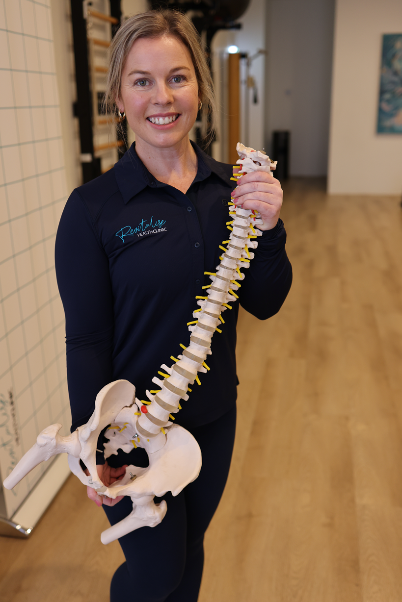 Meagan Kerr, Authorized Scolio-Pilates practitioner in Port Kennedy, Western Australia, standing with a spine in her studio in professional portrait