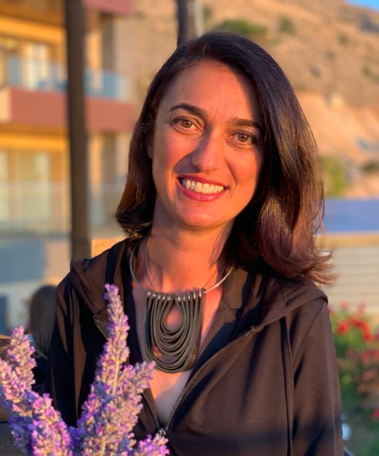 Nisreen Witt, Authorized Scolio-Pilates practitioner in the South of France, smiling outdoors at sunset