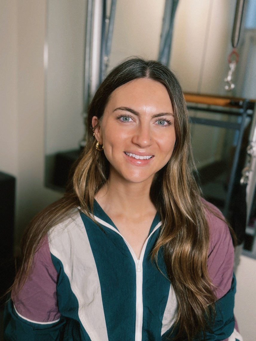 Olivia Cain, Authorized Scolio-Pilates practitioner in Los Angeles, California, smiling in her studio in a professional portrait