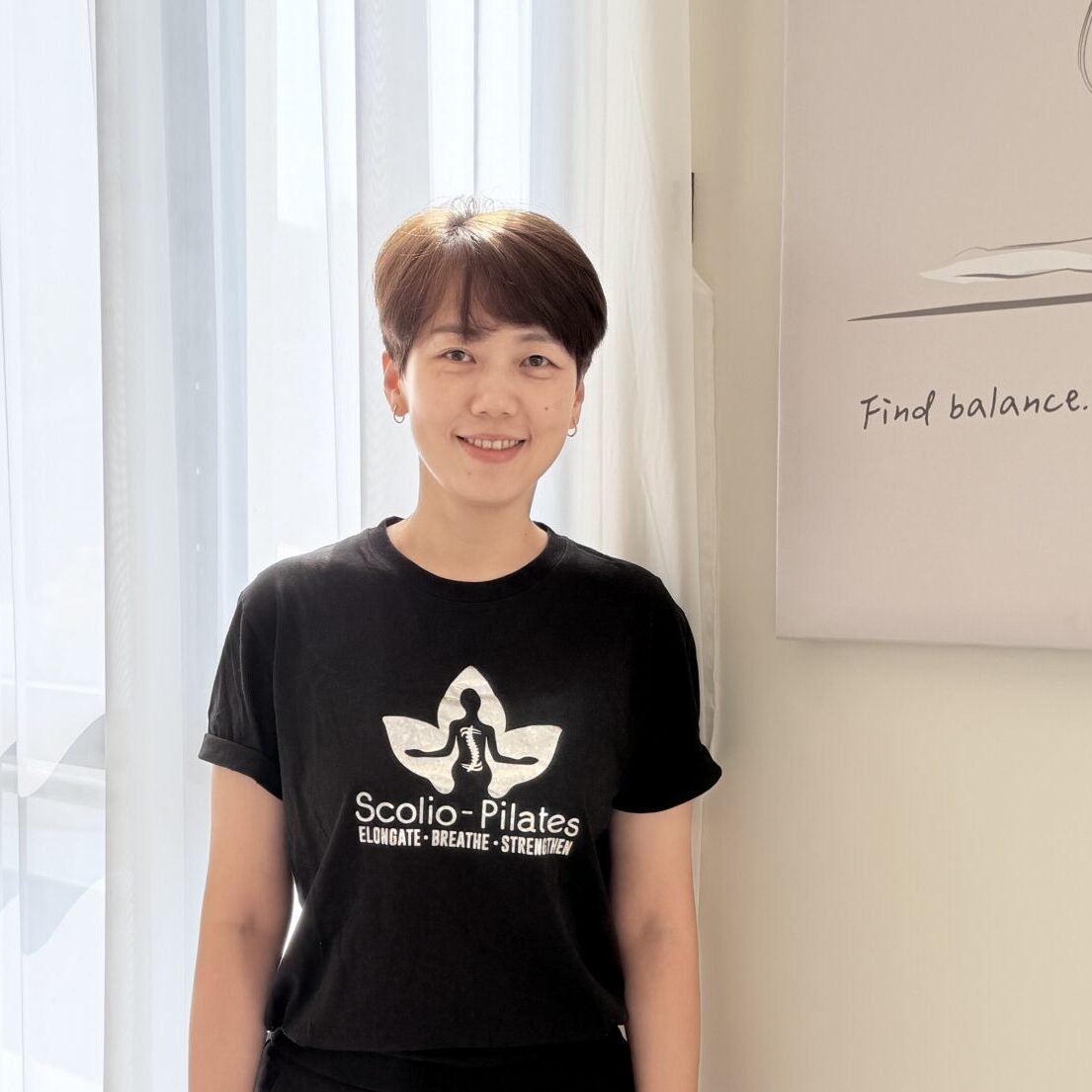 Annie Tai, Scolio-Pilates educator and practitioner in Taipei, Taiwan, standing in a Scolio-Pilates shirt