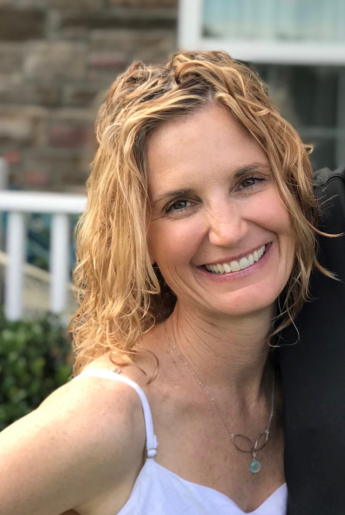 Karena Thek, founder of Scolio-Pilates, smiling in a professional portrait
